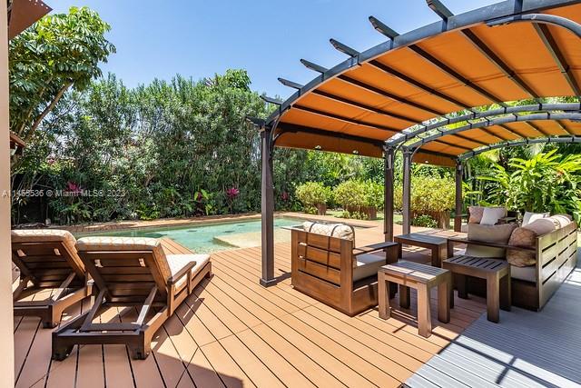 A wooden deck features lounge chairs and a pergola overlooking a backyard swimming pool — 800 S Del Cementerio, CR 0000, CR