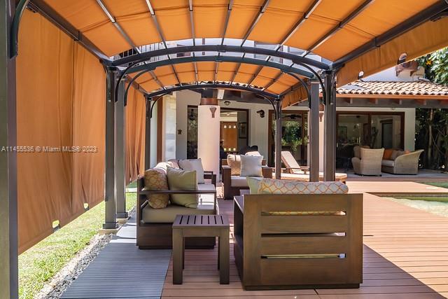 A covered outdoor patio features wooden furniture and a pergola overlooking a swimming pool — 800 S Del Cementerio, CR 0000, CR