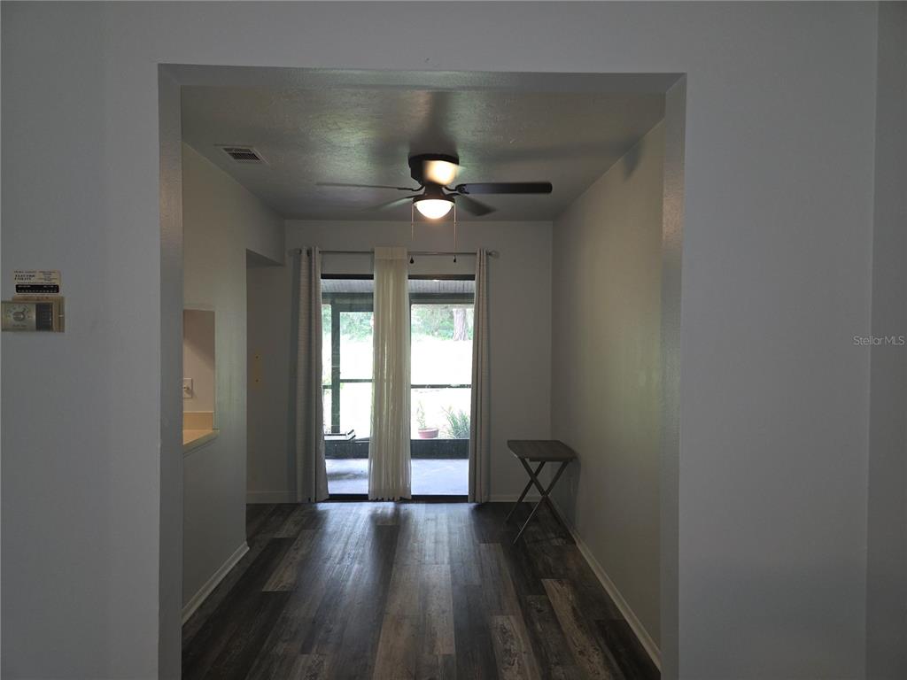 A dining area features wood-look flooring, a ceiling fan, and sliding glass doors to a patio — 1701 SE 24TH ROAD UNIT 103, OCALA, FL