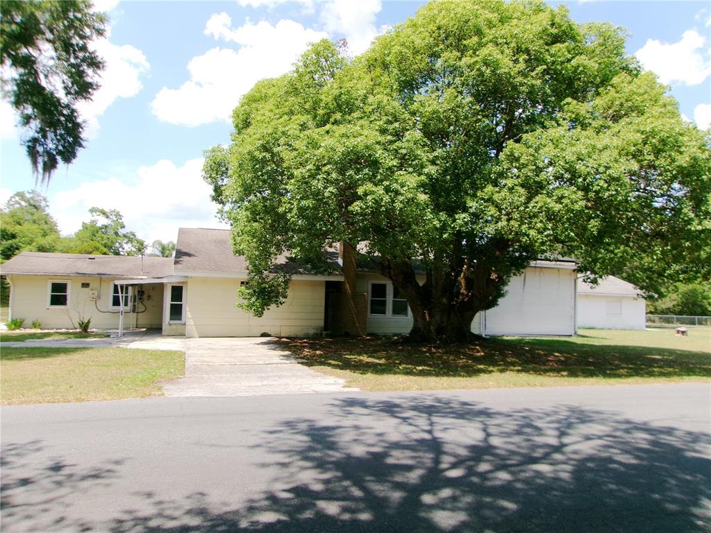 A single-story house with a large tree in the front yard and a concrete driveway — 5714 19TH STREET, ZEPHYRHILLS, FL