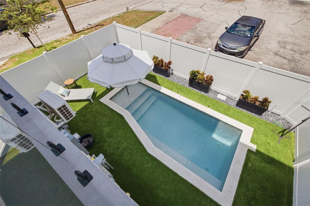An aerial view shows a small backyard with a rectangular pool, artificial turf, and fencing — 2502 N HIGHLAND AVENUE UNIT 1, TAMPA, FL