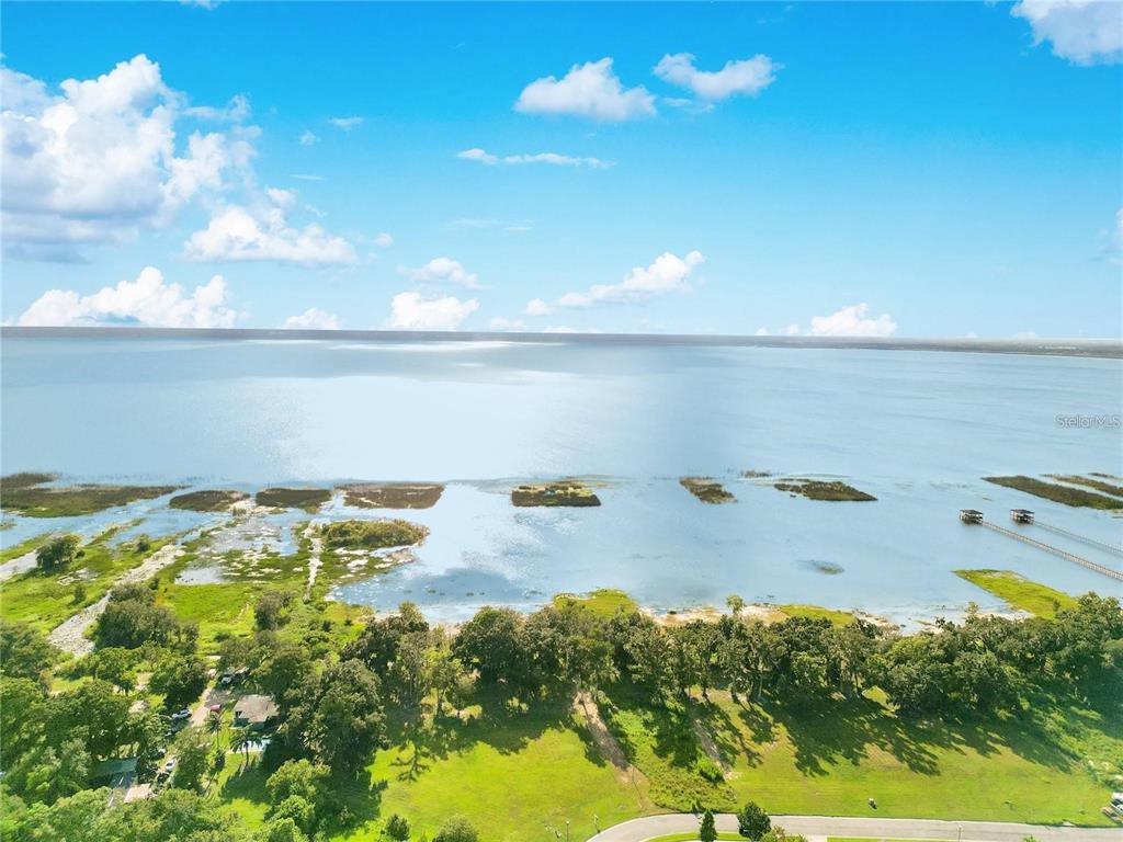 A sunset view over a marshy lake with two birds standing in the shallow water — 4810 CALASANS AVENUE, ST CLOUD, FL