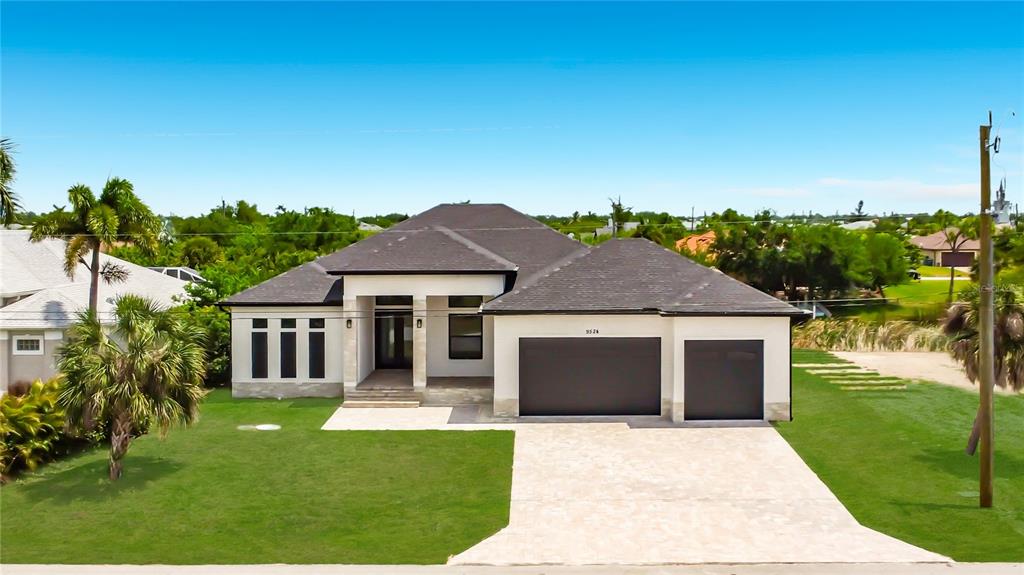 A single-story house with a dark roof, white exterior, and a three-car garage — 9524 SINGER CIRCLE, PORT CHARLOTTE, FL