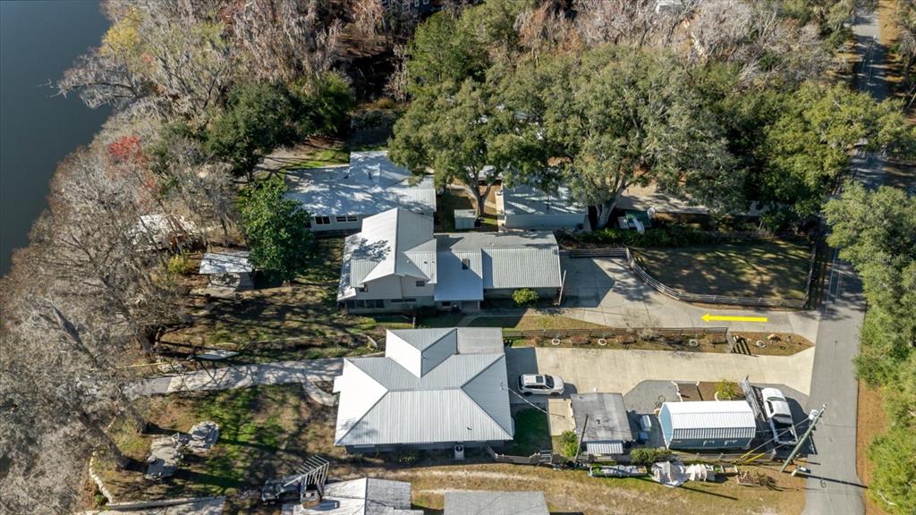 An aerial view shows two houses with metal roofs situated near a body of water — 28330 PETERSON CAMP ROAD, BROOKSVILLE, FL