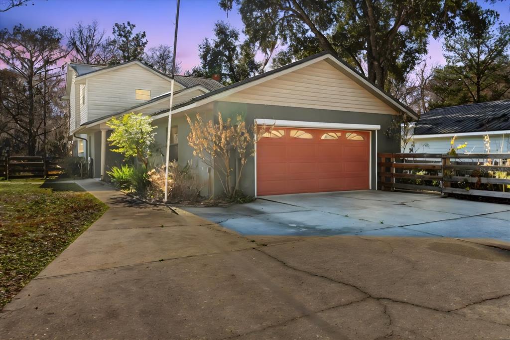 A two-story house with a gray exterior, a red garage door, and a concrete driveway — 28330 PETERSON CAMP ROAD, BROOKSVILLE, FL