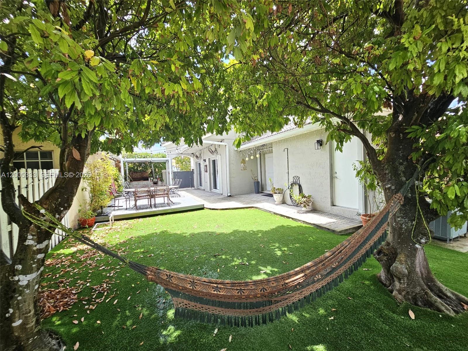 A backyard features a hammock strung between two trees over a green artificial lawn — 15429 SW 92nd St, Miami FL 33196, MIAMI, FL