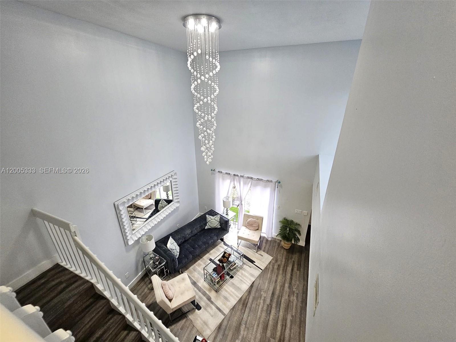 A high-angle view shows a living room with a tall chandelier, sofa, and staircase — 15429 SW 92nd St, Miami FL 33196, MIAMI, FL
