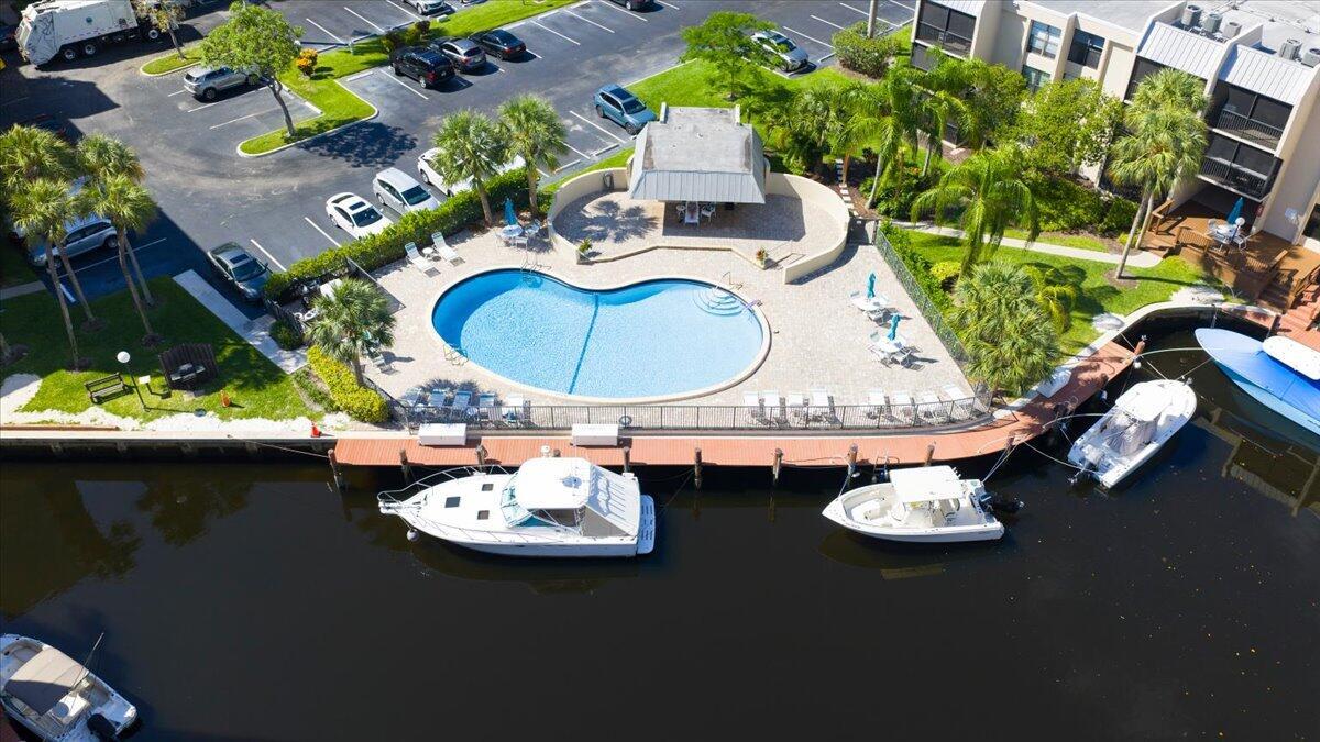 An aerial view of a swimming pool, patio area, and boat docks along a canal — 16 Royal Palm Way # 205, Boca Raton FL 33432, BOCA RATON, FL