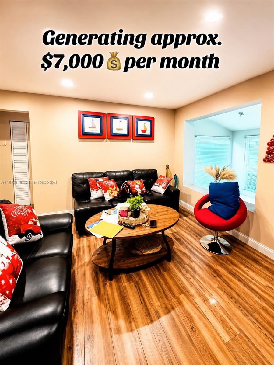A living room features wood-look flooring, black leather sofas, a round coffee table, and a red chair — 2281 NW 81st Ter, Miami FL 33147, MIAMI, FL