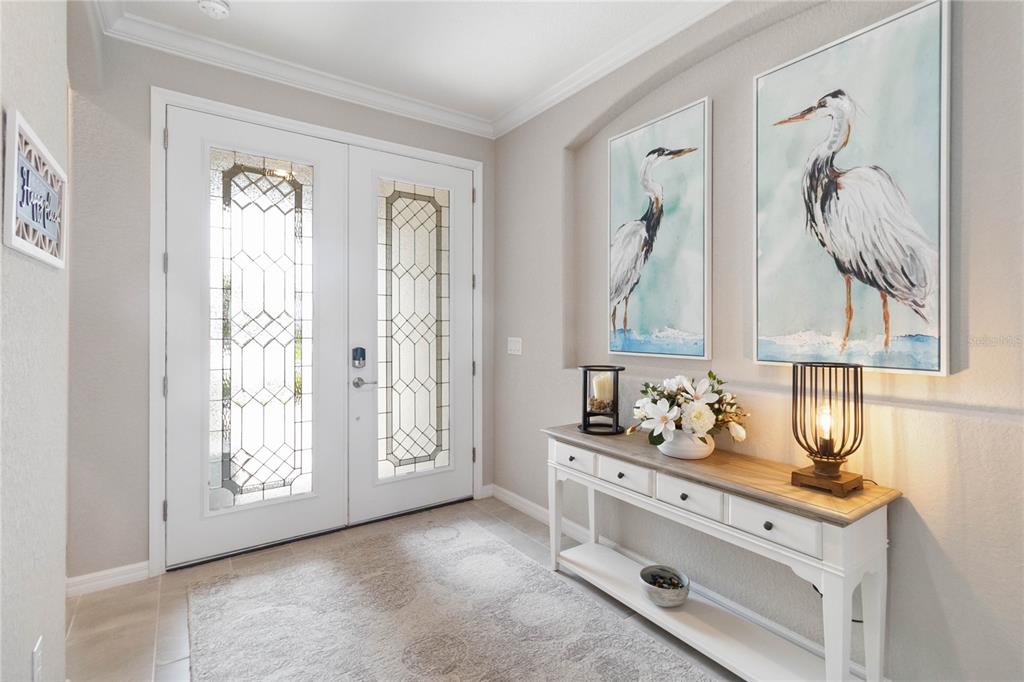 An entryway features a white double door, a console table, and two heron wall paintings — 17724 POLO TRAIL, LAKEWOOD RANCH, FL
