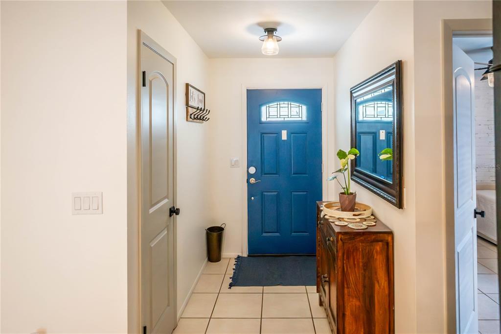 An entryway features a blue front door, tile flooring, a wooden console table, and mirror — 623 HOLBROOK CIRCLE, LAKE MARY, FL