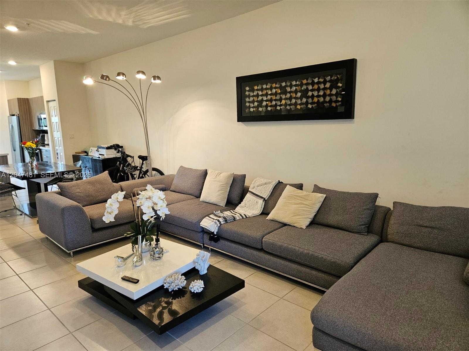 A living room features a large gray sectional sofa, a two-tiered coffee table, and artwork — 8195 NW 104th Ave # 23, Doral FL 33178, DORAL, FL