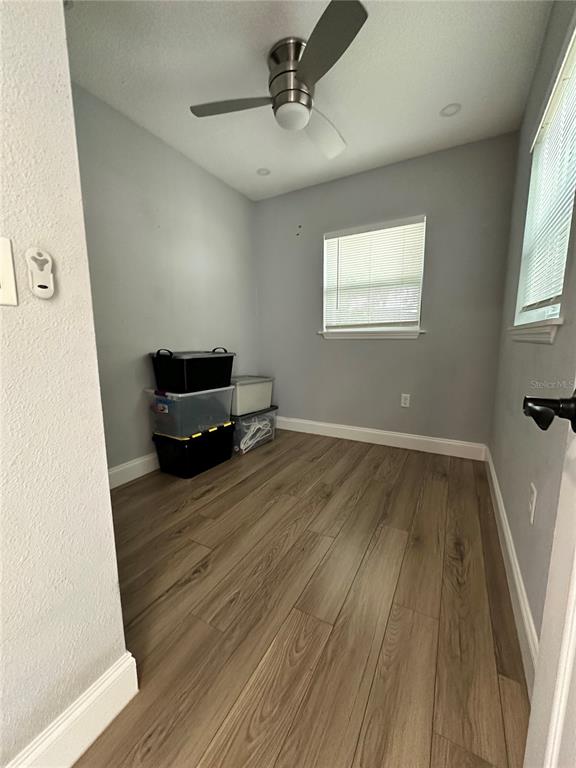 A small room with light gray walls, wood-look flooring, a ceiling fan, and storage bins — 4521 EDGEWATER DRIVE UNIT 2, ORLANDO, FL