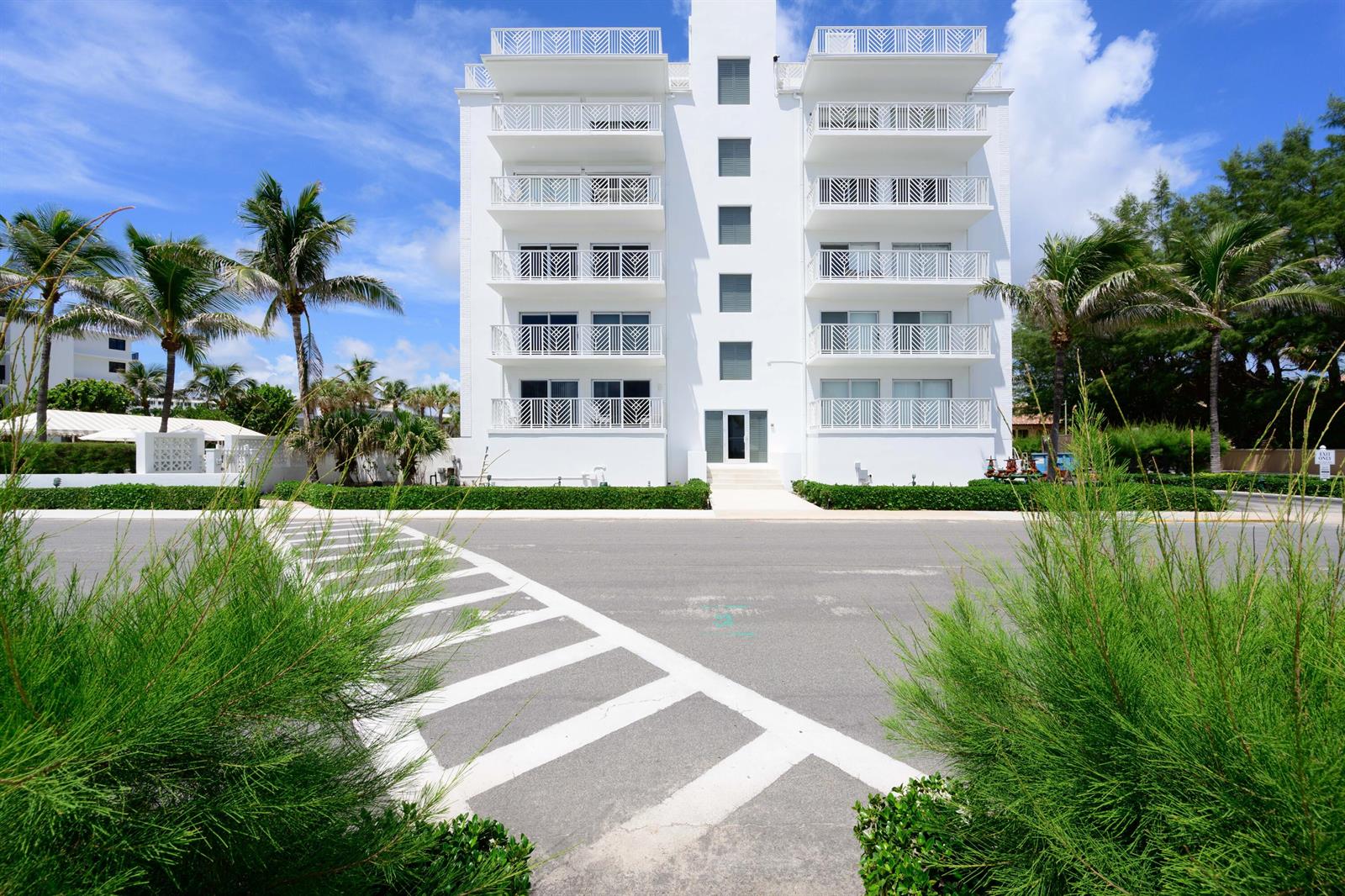 A white five-story apartment building stands behind a paved road with a crosswalk — 170 N Ocean Boulevard # 303, Palm Beach FL 33480, PALM BEACH, FL