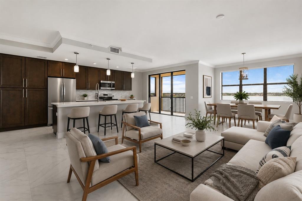 A modern open-concept kitchen, dining area, and living room with tile floors and water views — 16300 COUNTY ROAD 455 UNIT 410, MONTVERDE, FL