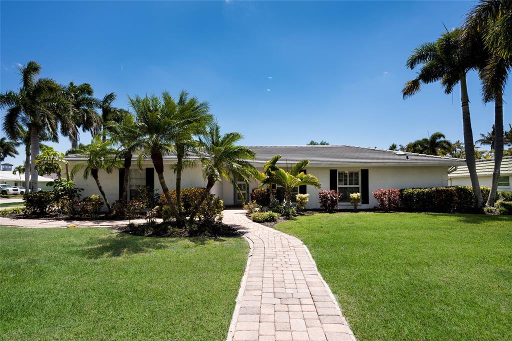 A single-story house with a paved walkway, palm trees, and a green lawn — 430 BIRD KEY DRIVE, SARASOTA, FL