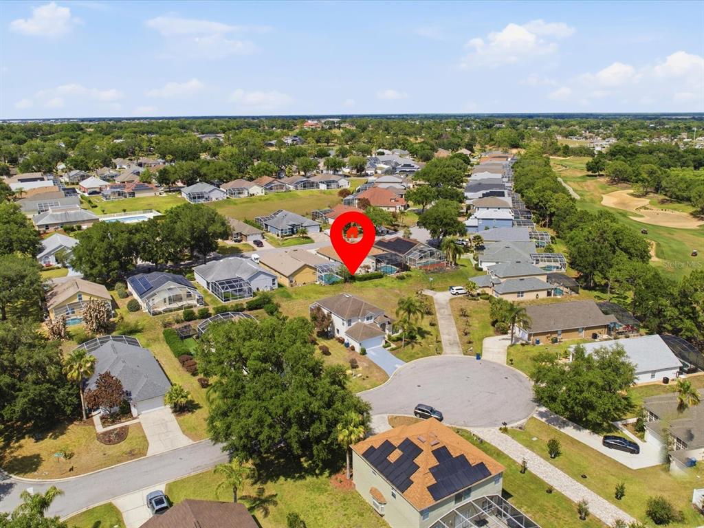 An aerial view shows a suburban neighborhood with a red pin marking a specific house — 1656 DUNES COURT, HAINES CITY, FL