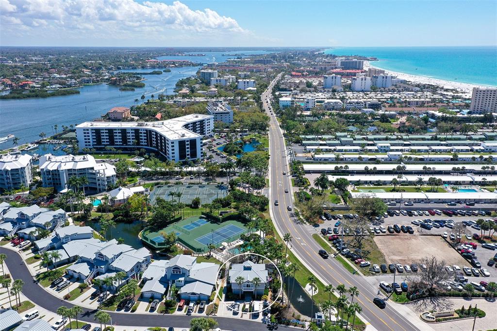An aerial view shows a residential neighborhood with a circled house near a coastal road — 1200 SIESTA BAYSIDE DRIVE UNIT 1200G, SARASOTA, FL
