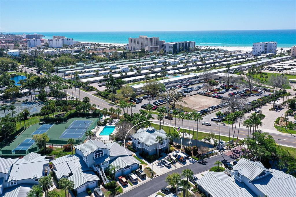 An aerial view shows a two-story gray house circled in a residential coastal community — 1200 SIESTA BAYSIDE DRIVE UNIT 1200G, SARASOTA, FL