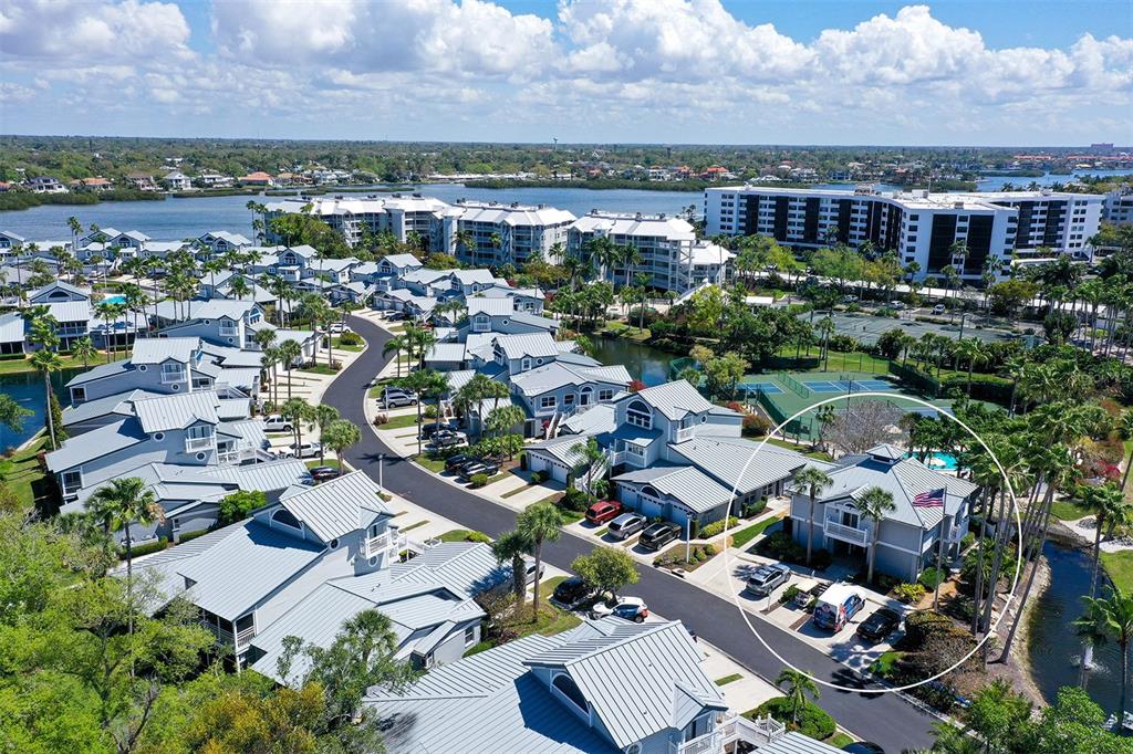 An aerial view of a residential complex featuring multi-story buildings, palm trees, and a pool — 1200 SIESTA BAYSIDE DRIVE UNIT 1200G, SARASOTA, FL