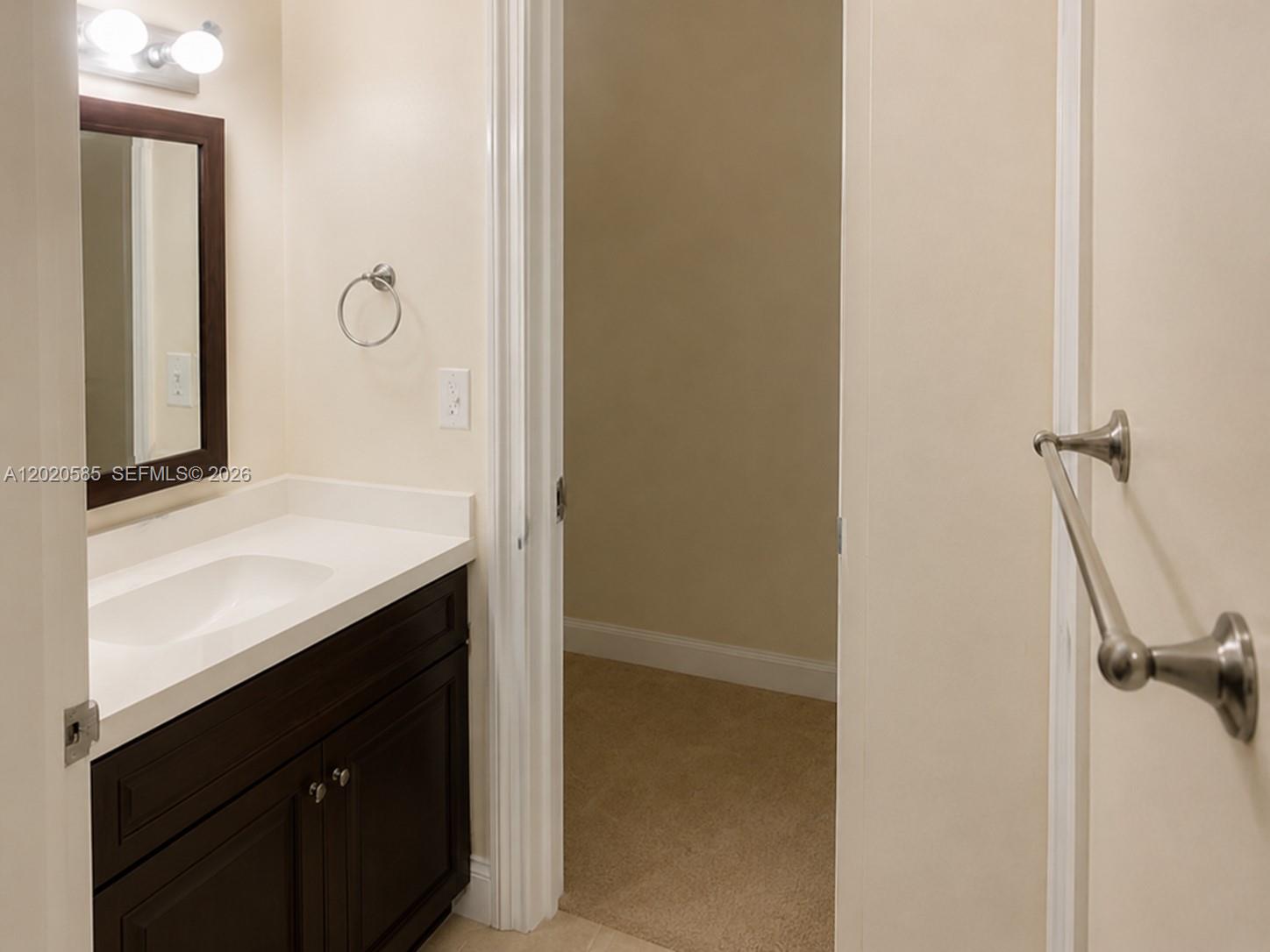 A bathroom features a dark wood vanity with a white countertop and a carpeted room — 13255 SW 88 LN, Kendall FL 33186, KENDALL, FL