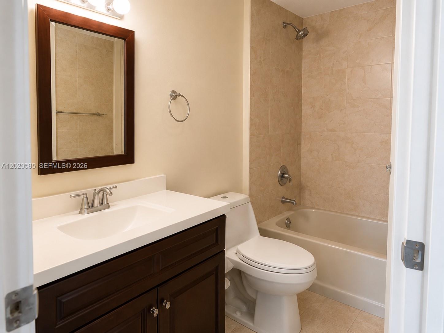 A bathroom features a dark wood vanity, white countertop, toilet, and a tiled shower-tub combo — 13255 SW 88 LN, Kendall FL 33186, KENDALL, FL