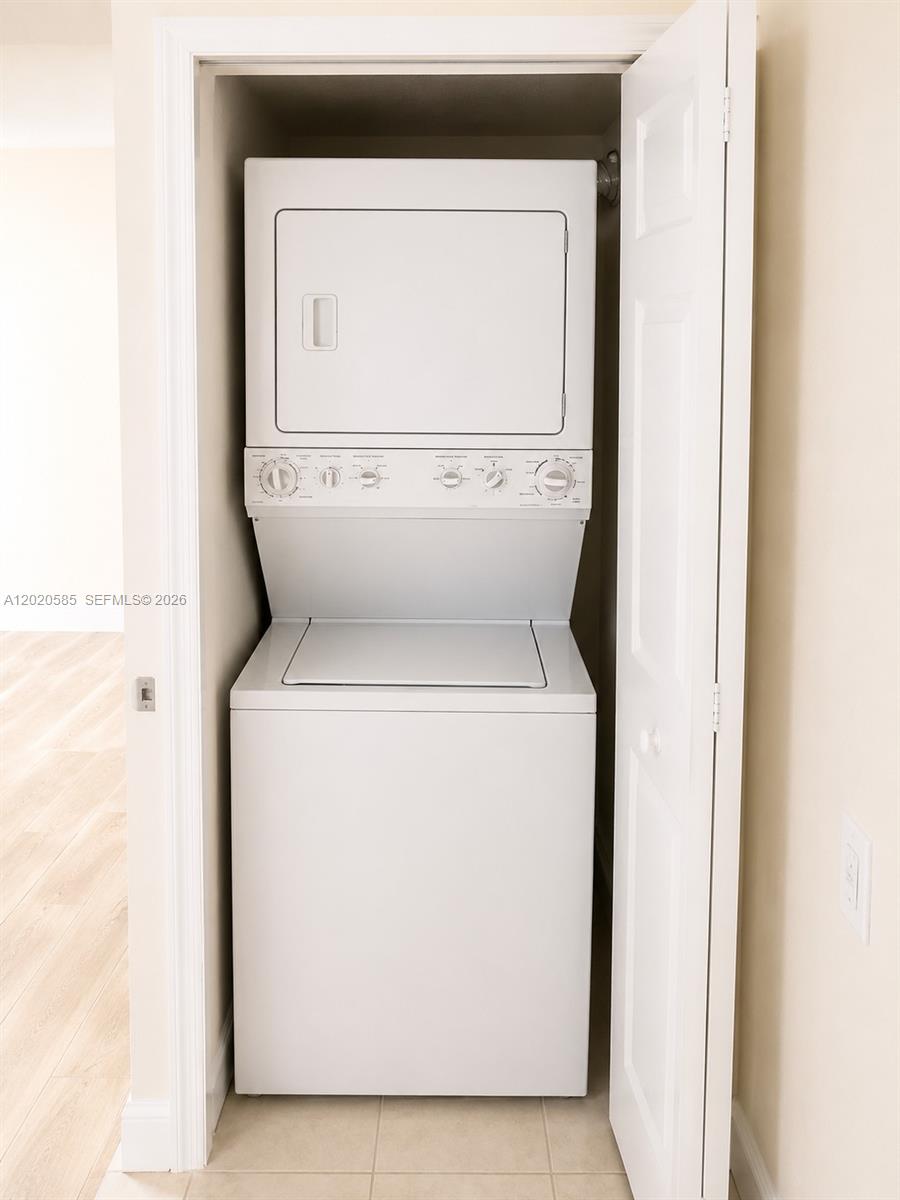A white stacked washer and dryer unit is installed inside a small closet — 13255 SW 88 LN, Kendall FL 33186, KENDALL, FL