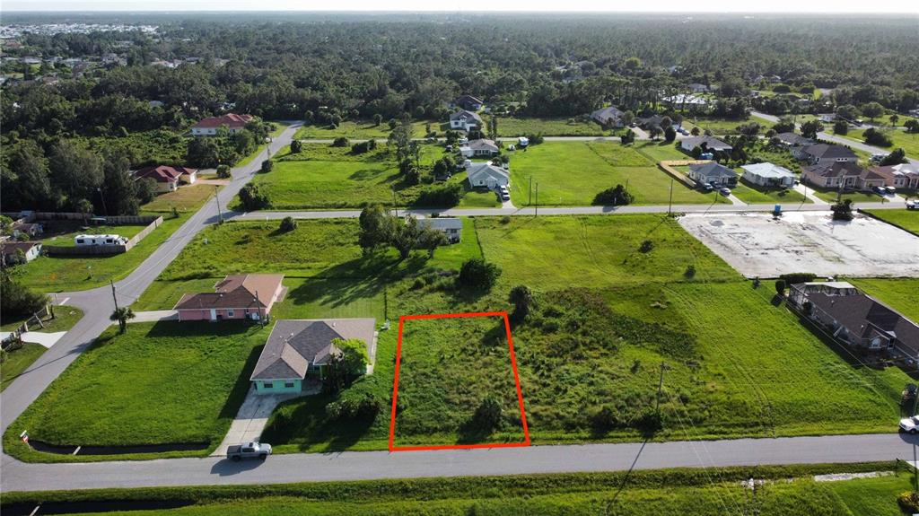 An aerial view shows a vacant rectangular lot outlined in red next to a house — HACIENDA ST, NORTH PORT, FL