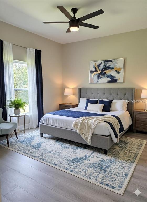 A bedroom features a gray tufted headboard, a blue and white rug, and a ceiling fan — 12208-10 TETZEL AVENUE, PORT CHARLOTTE, FL