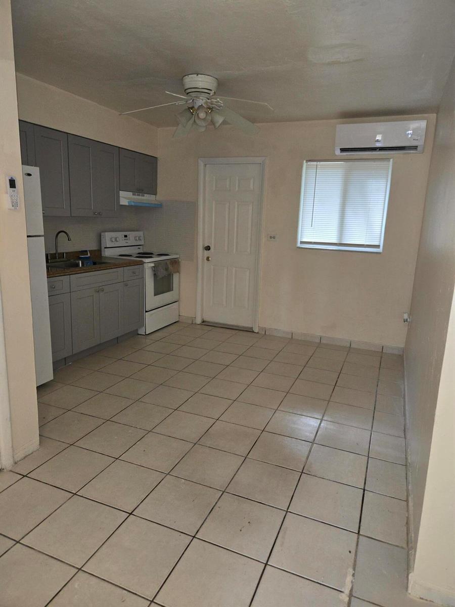 A kitchen with gray cabinets, white appliances, tile flooring, and a ceiling fan — 1560 NE 111th Street # 3, Miami FL 33161, MIAMI, FL