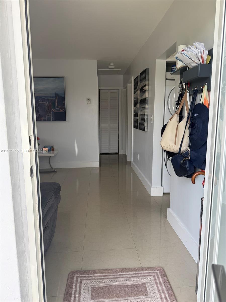 A tiled entryway leads to a hallway with a closet and a wall-mounted coat rack — 10030 SW 213th Ter, Cutler Bay FL 33189, CUTLER BAY, FL