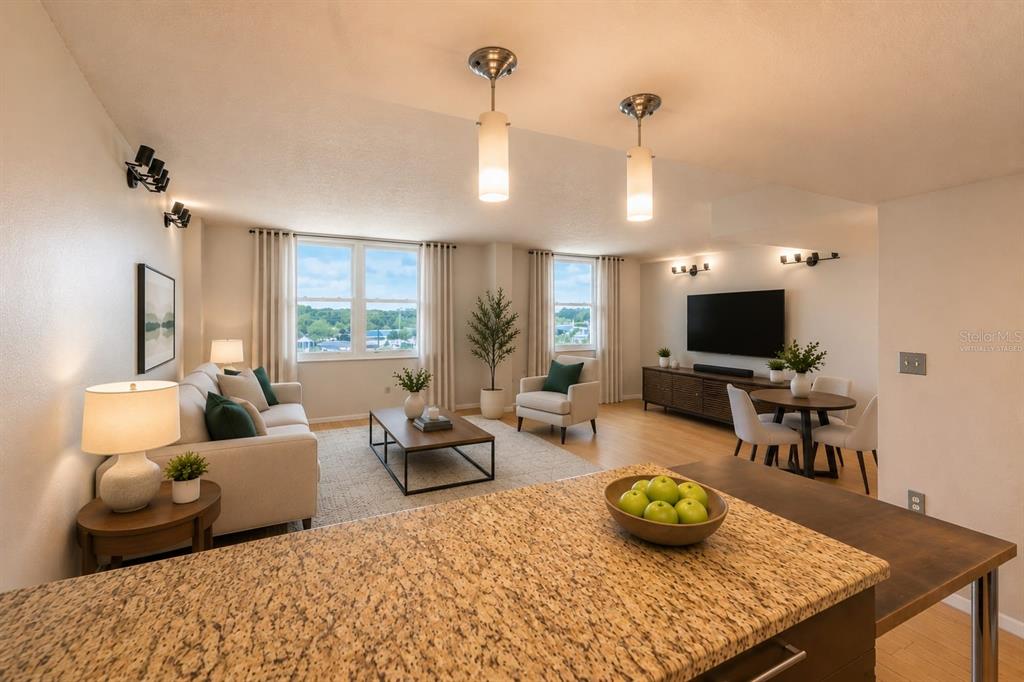 This living and dining area features a granite-topped kitchen island and large windows — 701 S MADISON AVENUE UNIT 502, CLEARWATER, FL