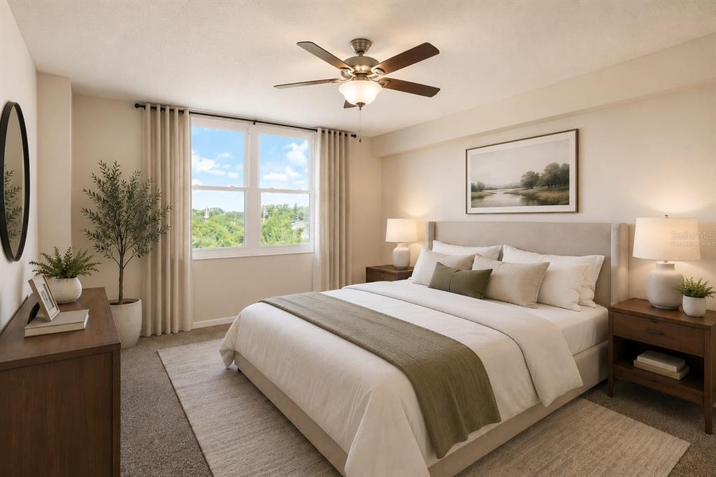 A bedroom features a queen bed, a ceiling fan, and a window with outdoor views — 701 S MADISON AVENUE UNIT 502, CLEARWATER, FL
