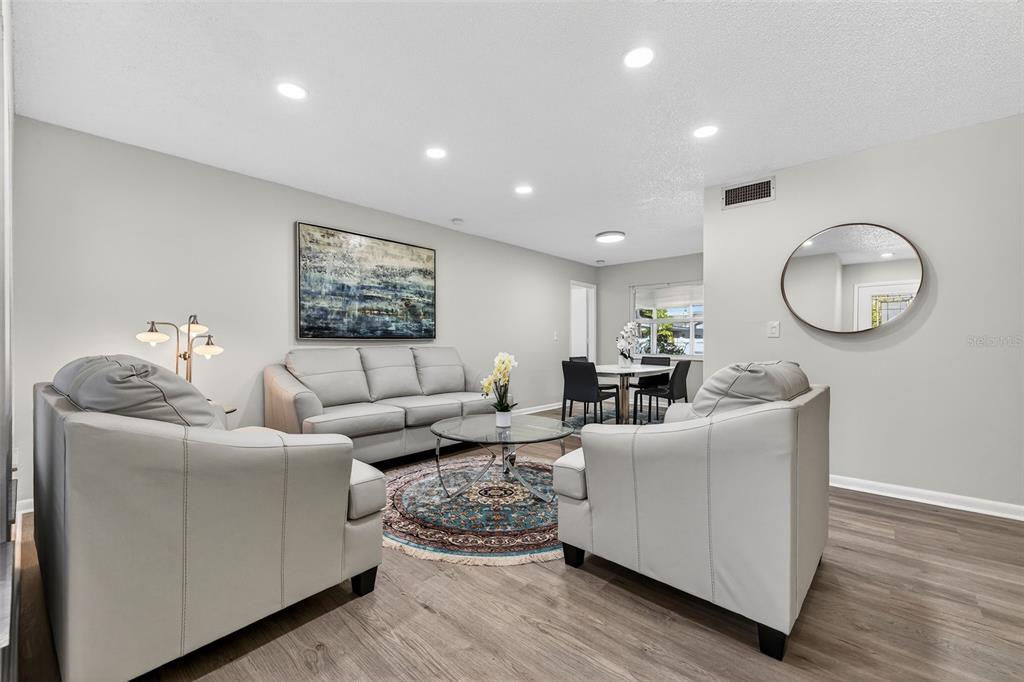 A living room with light gray walls, white leather furniture, and a round area rug — 10275 113TH STREET, SEMINOLE, FL