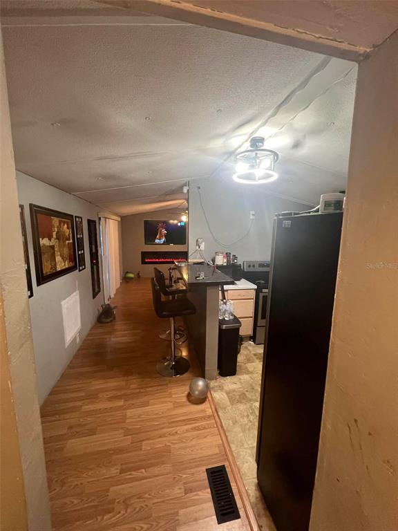 A view from a doorway into a kitchen with a breakfast bar and living area — 10809 SE 129TH STREET, BELLEVIEW, FL