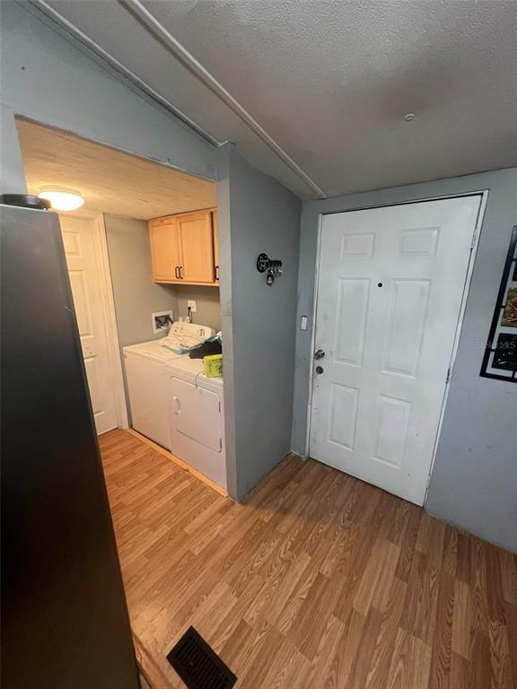 A laundry area with a washer and dryer sits beside a white exterior door — 10809 SE 129TH STREET, BELLEVIEW, FL