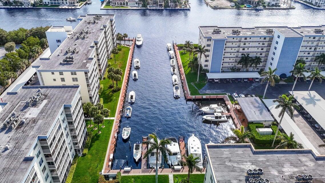 An aerial view shows a canal lined with apartment buildings and multiple docked boats — 1 Harbourside Drive # 4205, Delray Beach FL 33483, DELRAY BEACH, FL