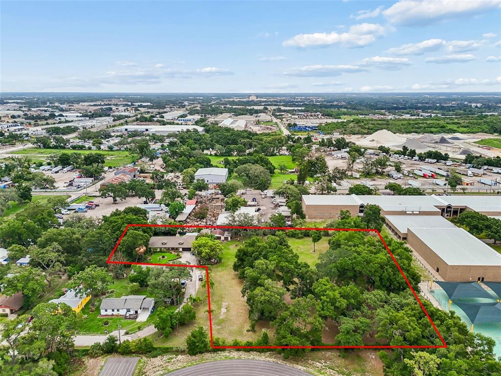 An aerial view shows a house on a large, tree-filled lot outlined in red — 5105 N 45TH STREET, TAMPA, FL
