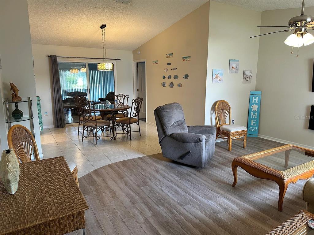 A living and dining area features tile and wood-look flooring, a ceiling fan, and furniture — 17808 SE 107TH TERRACE, SUMMERFIELD, FL