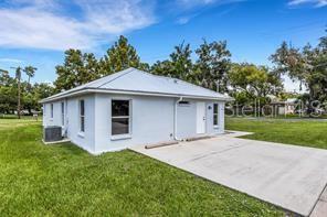 An empty room features light-colored walls, wood-look flooring, a ceiling fan, and a white door — 3100 W REYNOLDS STREET, PLANT CITY, FL