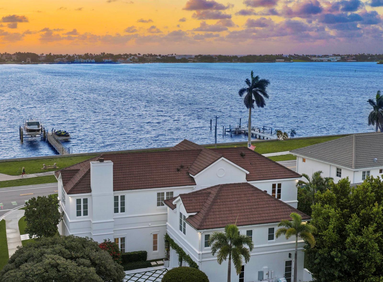 An aerial view of a white waterfront house with a brown roof and private dock — 5501 S Flagler Drive, West Palm Beach FL 33405, WEST PALM BEACH, FL