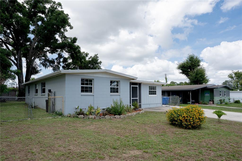 A light blue, single-story concrete block house with a front yard and adjacent carport — 711 MASON STREET, BRANDON, FL