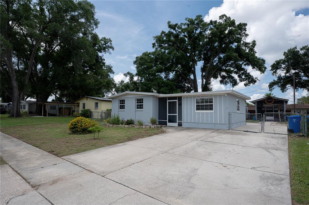 A single-story light blue house with a concrete driveway and a chain-link fence — 711 MASON STREET, BRANDON, FL