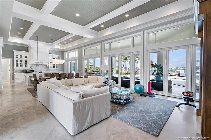 A spacious living room with a coffered ceiling, white sofa, and large glass doors — 2941 Lake Drive, Singer Island FL 33404, SINGER ISLAND, FL