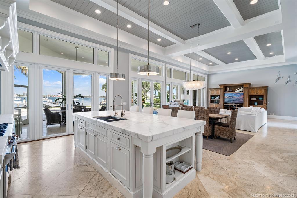 A bright, open-concept kitchen and living area features a large marble island and coffered ceilings — 2941 Lake Drive, Singer Island FL 33404, SINGER ISLAND, FL