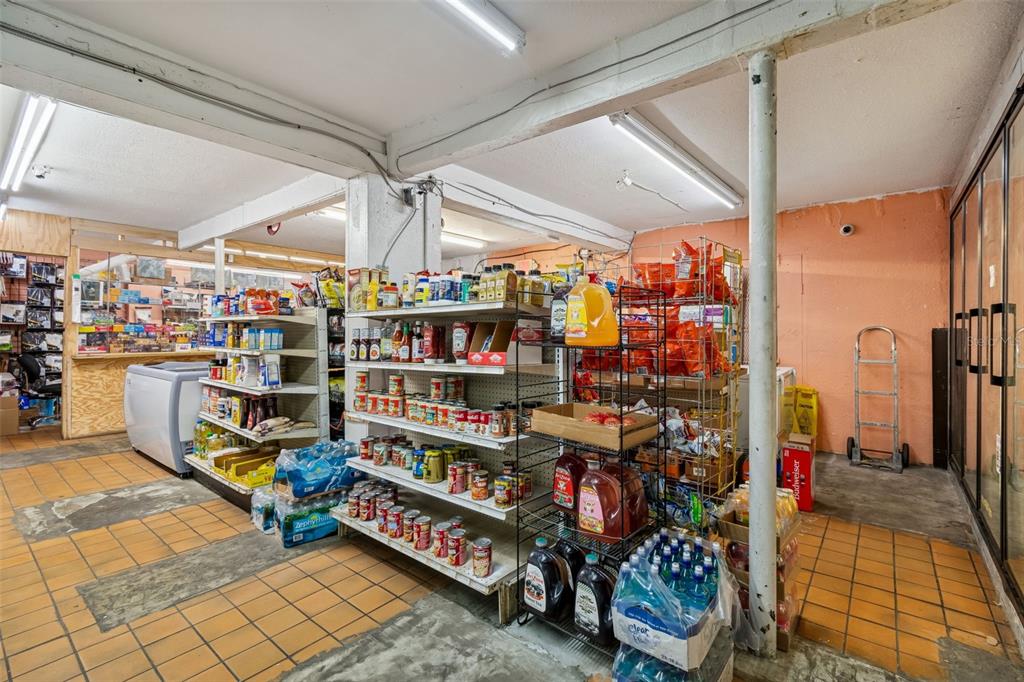A convenience store interior features metal shelving units stocked with various food and beverage products — 1664 15TH AVENUE S, ST PETERSBURG, FL