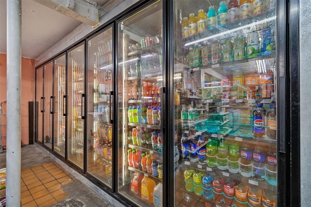 A row of commercial glass-door refrigerators filled with various bottled beverages in a store — 1664 15TH AVENUE S, ST PETERSBURG, FL