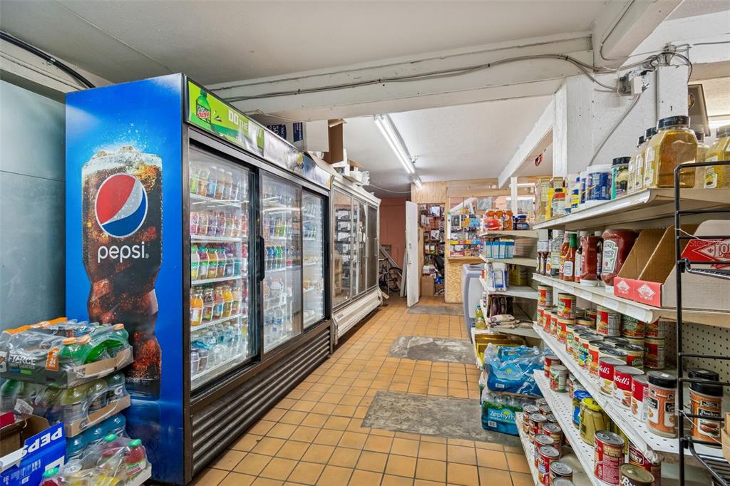A small convenience store interior features refrigerated display cases and shelves stocked with various goods — 1664 15TH AVENUE S, ST PETERSBURG, FL