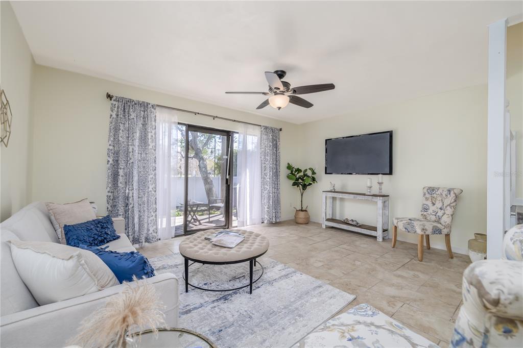 A living room features tile floors, a ceiling fan, a sofa, and a sliding glass door — 3333 S RIDGEWOOD AVENUE UNIT 27G, PORT ORANGE, FL