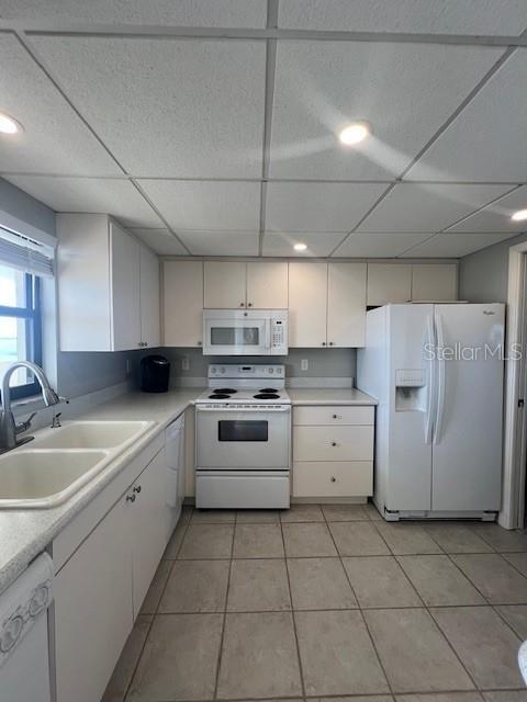 A kitchen features white cabinets, white appliances, a double sink, and tiled flooring — 1230 GULF BOULEVARD UNIT 1507, CLEARWATER, FL